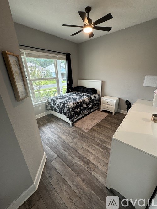 A bedroom with a bed, dresser, and window.