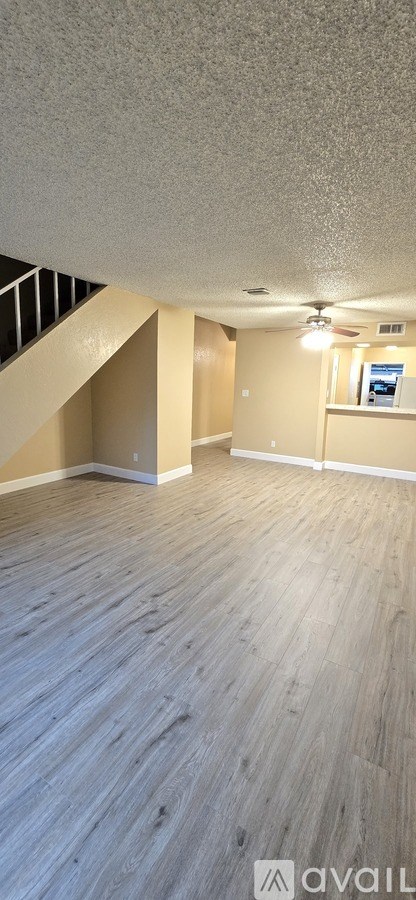 A room with wooden flooring and a staircase.