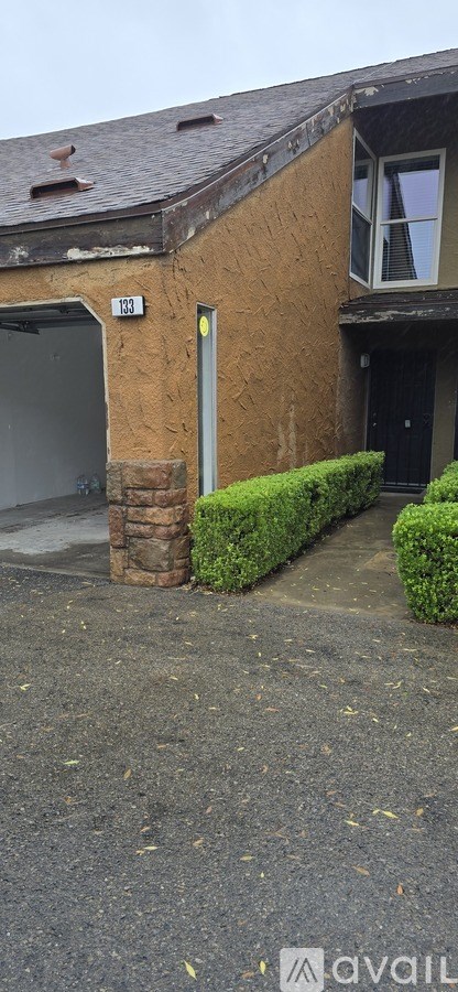 A house with a brown wall and a grey door.