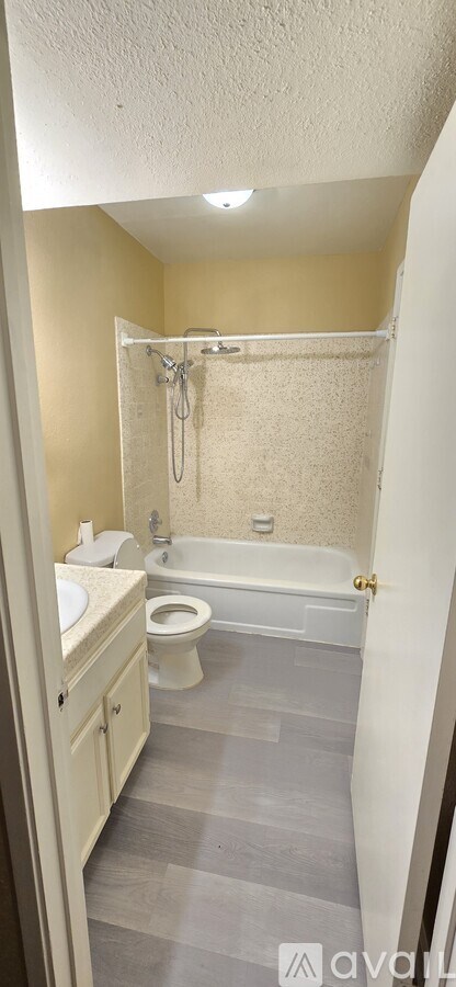 A bathroom with a toilet, sink, and bathtub.