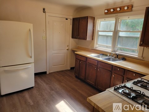 A kitchen with a white fridge and wooden cabinets.