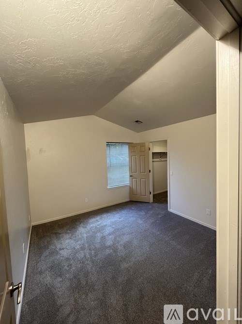 A room with a carpeted floor and a door leading to another room.