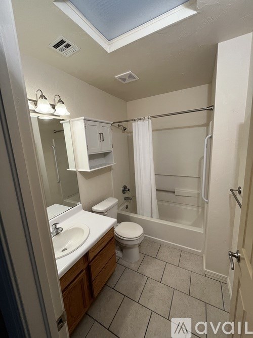 A bathroom with a skylight and a toilet.