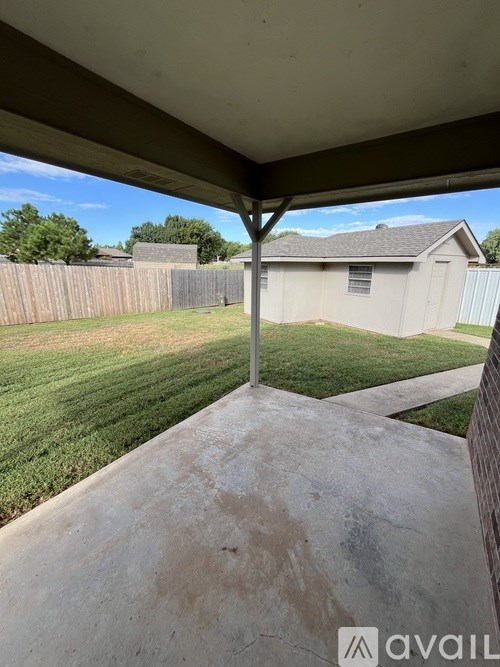A patio with a concrete floor and a wooden fence.