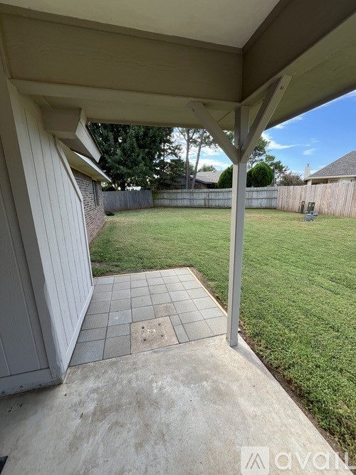 A patio area with a tiled floor and a white wall.