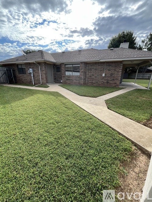 A house with a grey roof and a green lawn.