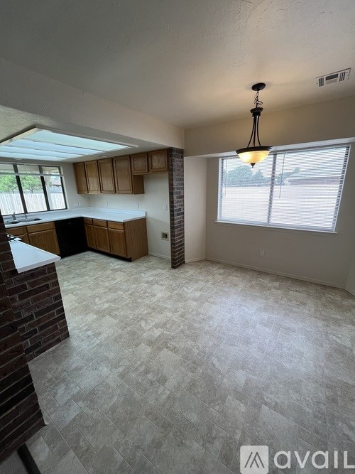 A kitchen with a brick column and a tiled floor.