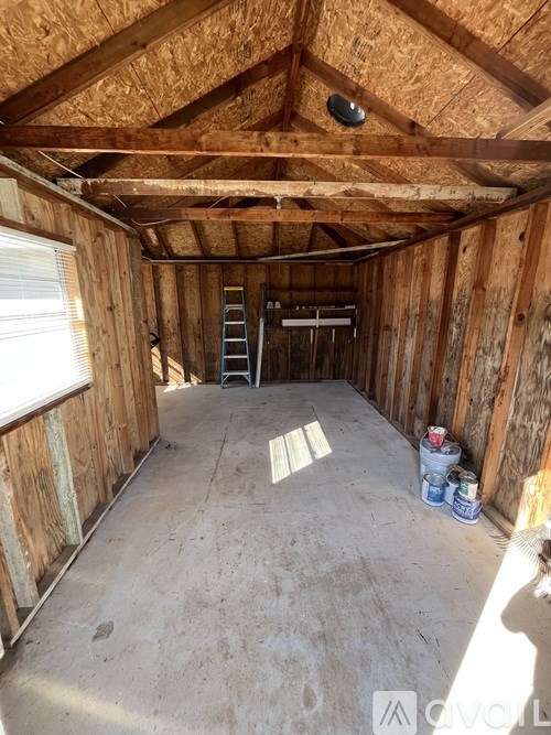 A room under construction with a ladder and some paint cans.