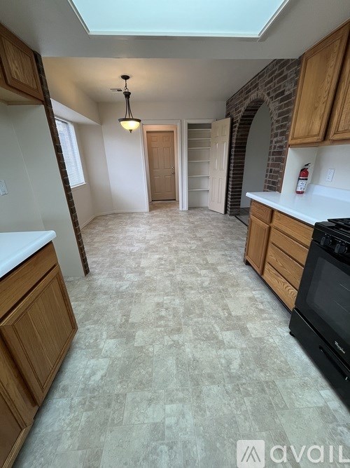A kitchen with a tiled floor and a skylight.