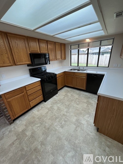 A kitchen with wooden cabinets and black appliances.