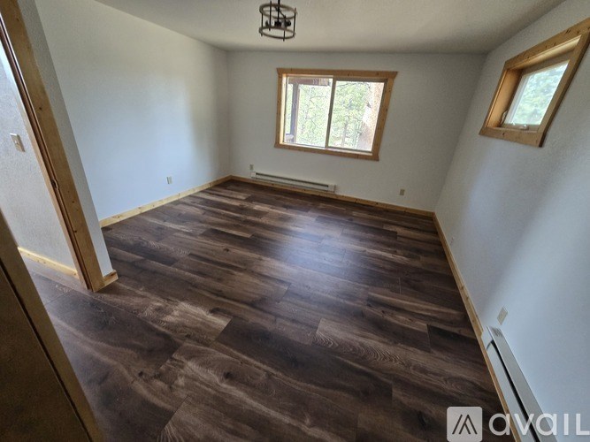 A room with wooden flooring and a window.