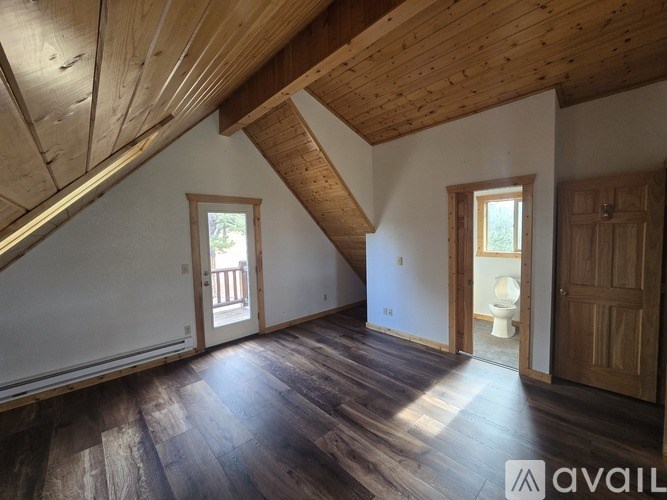 A room with wooden floors and a wooden ceiling with a window.