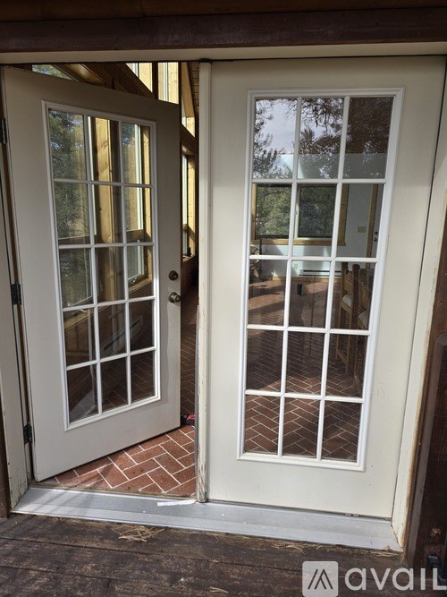A white double door with glass panels and a brick base.