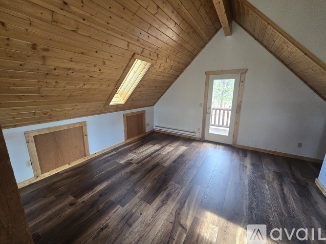 A room with wooden floors and a window.
