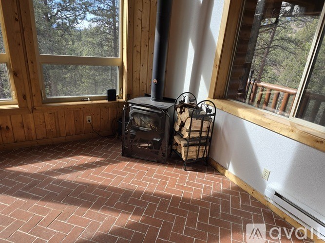 A wood stove and fireplace in a room with a brick floor.