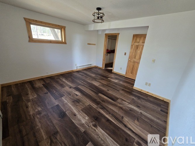 A room with wooden flooring and a window.