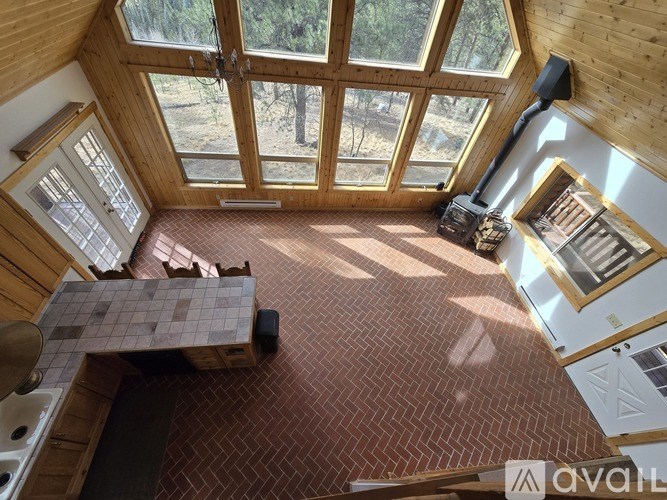 A sunny day in a wooden house with a kitchen and a wood stove.