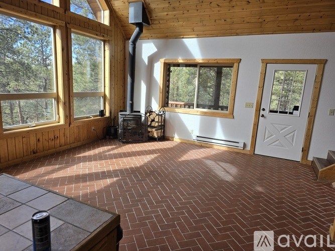 A room with a wood-burning stove and a brick floor.