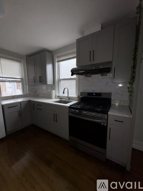 A kitchen with white cabinets and a black stove top oven.