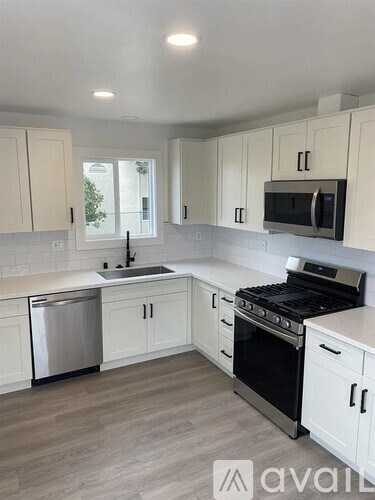 A kitchen with white cabinets and a stainless steel dishwasher.