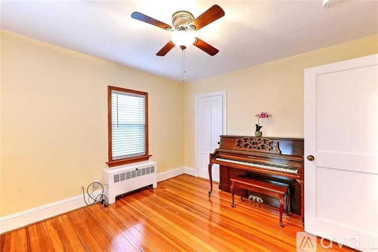A room with a piano and a fan.