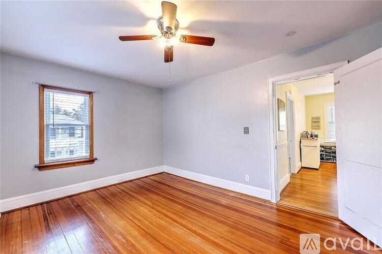 A room with wooden floors and a ceiling fan.