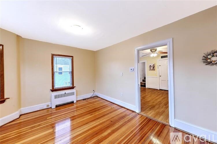 A room with wooden floors and a window with blinds.