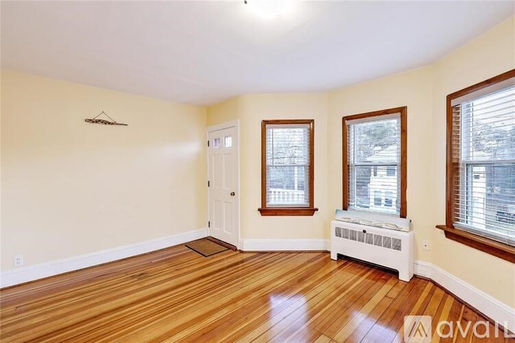 A room with wooden floors and a window with blinds.