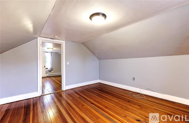 A room with wooden floors and a white ceiling with a light fixture.