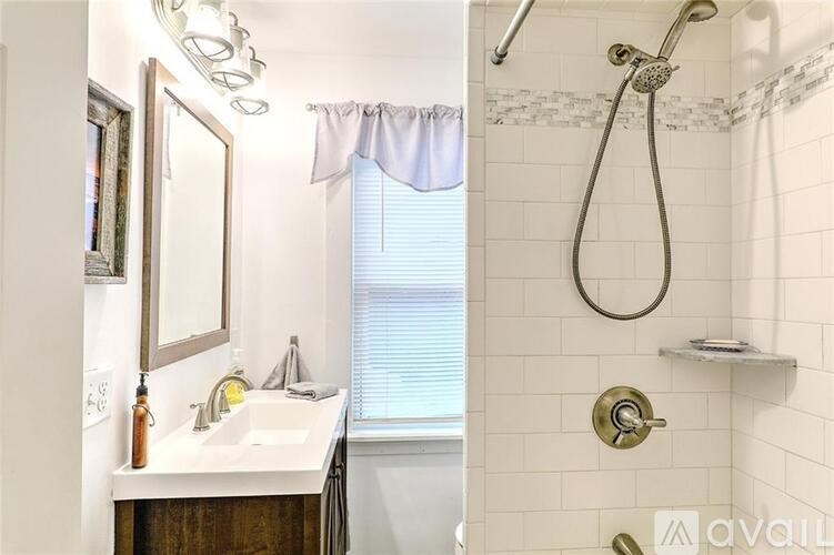 A bathroom with a white sink and a shower with a curtain.