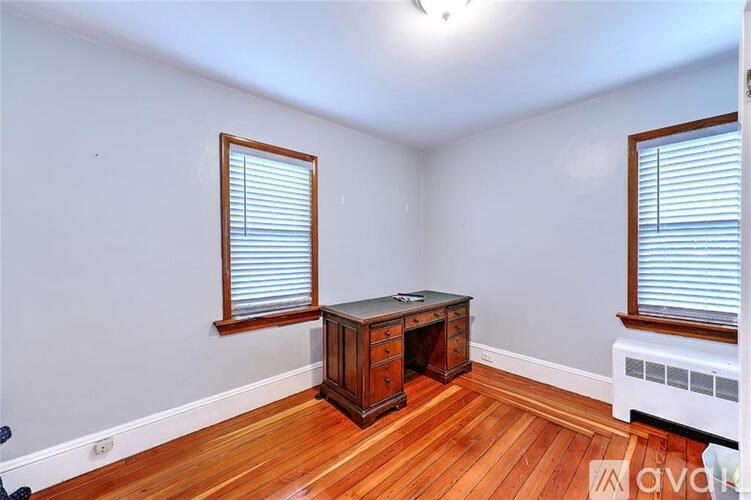 A room with wooden floors and a wooden cabinet with a television on top.