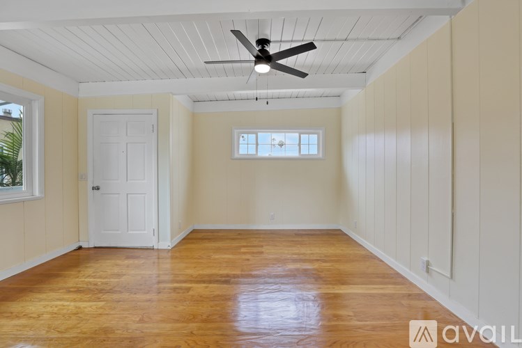A room with wooden floors and a ceiling fan.