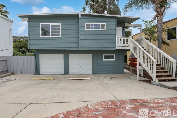 A two-story house with a garage and a balcony.