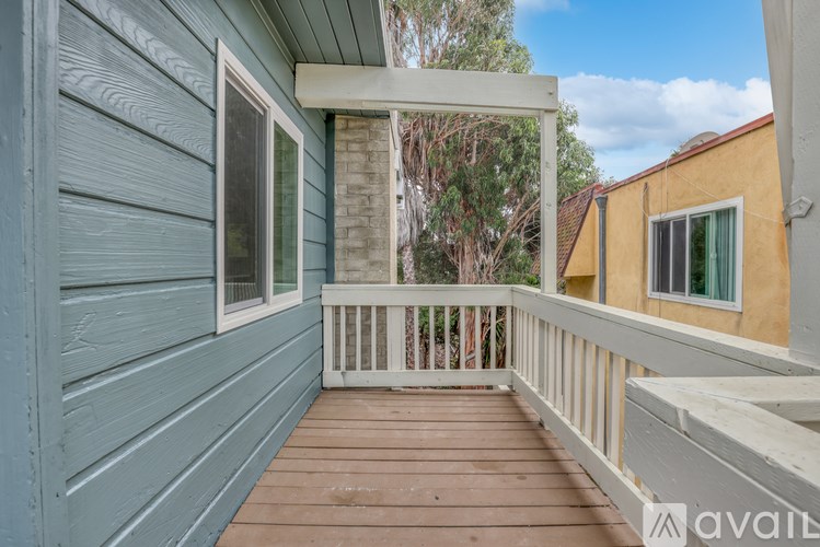A wooden deck with a white railing and a window.