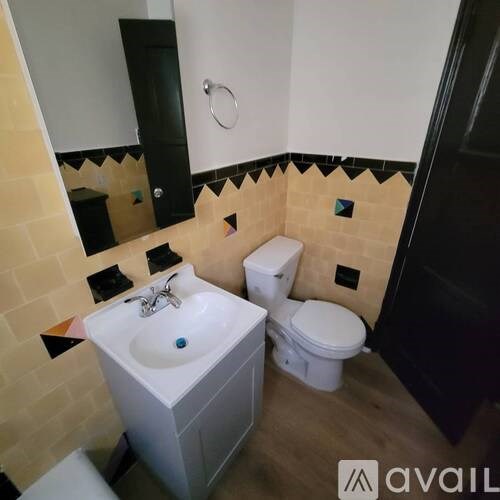 A bathroom with a sink, toilet and mirror.