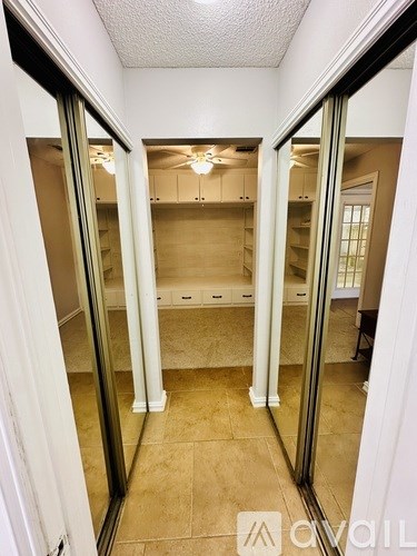 A hallway with a glass door and a white door.