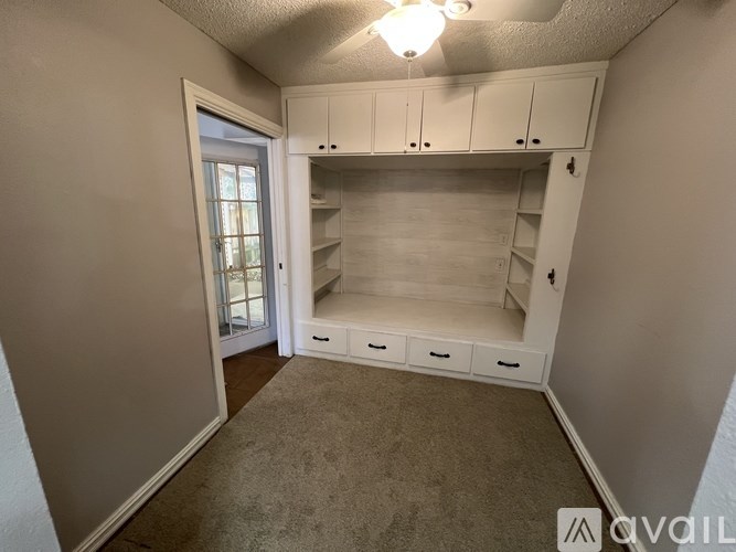 A room with white cabinets and drawers is available for rent.