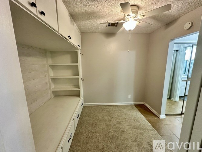 A room with a ceiling fan and a carpeted floor.