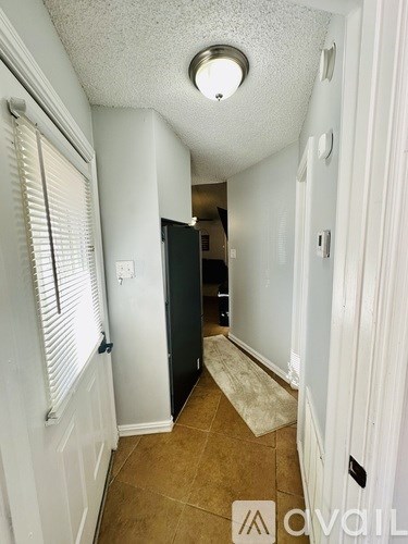 A hallway with a door on the left and a door on the right.