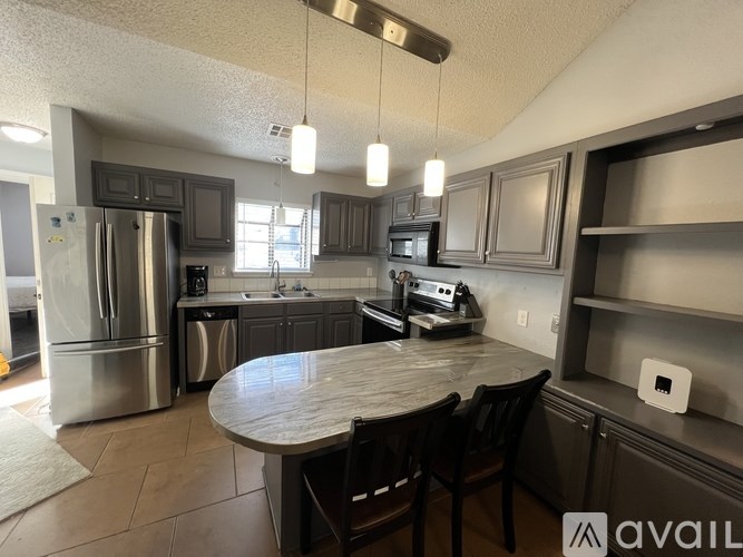 A kitchen with a table and chairs in the middle of the room.