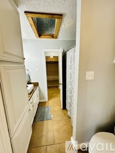 A hallway with a skylight and a door at the end.