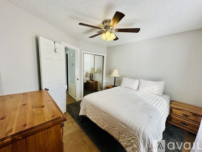 A bedroom with a bed, dresser, and mirror.