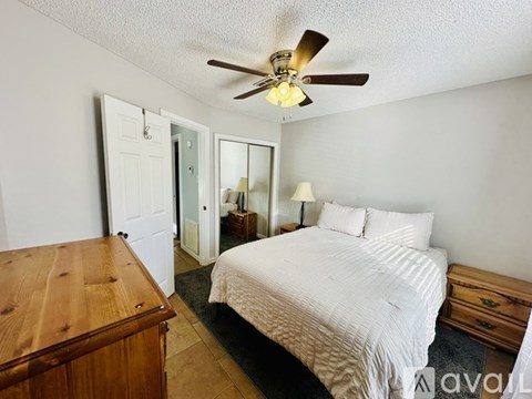 A bedroom with a bed, dresser, and mirror.