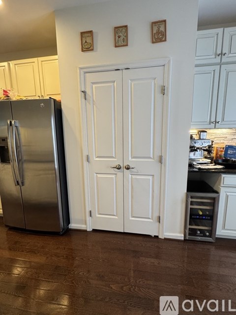A kitchen with a refrigerator and a white door.