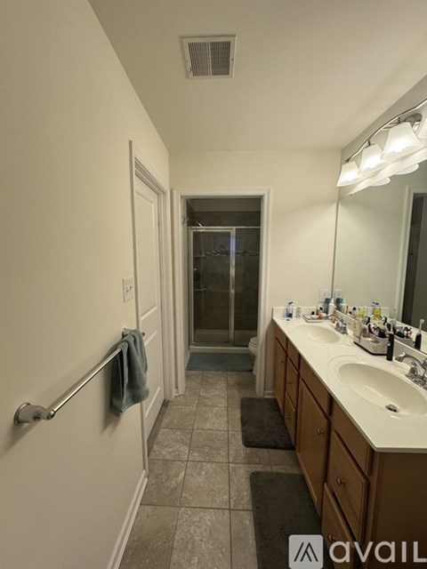 A bathroom with a sink, mirror, and a towel hanging on the towel rack.