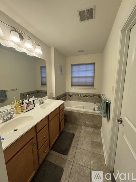 A bathroom with a tub, sink, and mirror.