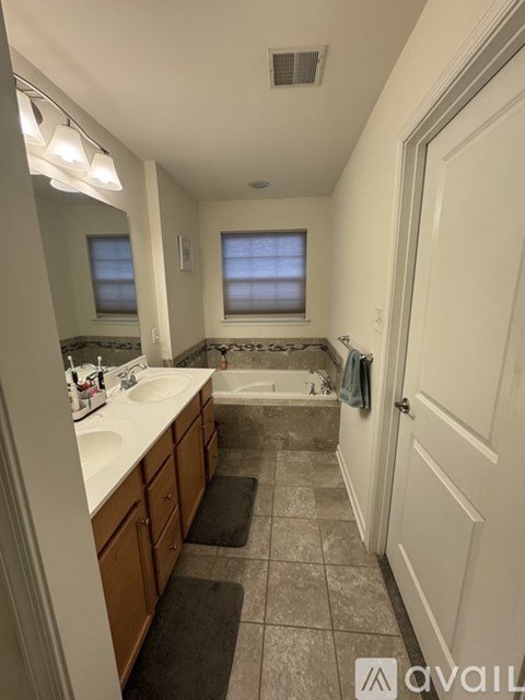 A bathroom with a white countertop and a window.