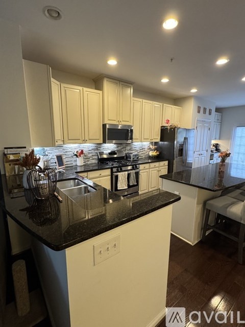 A kitchen with black countertops and white cabinets.