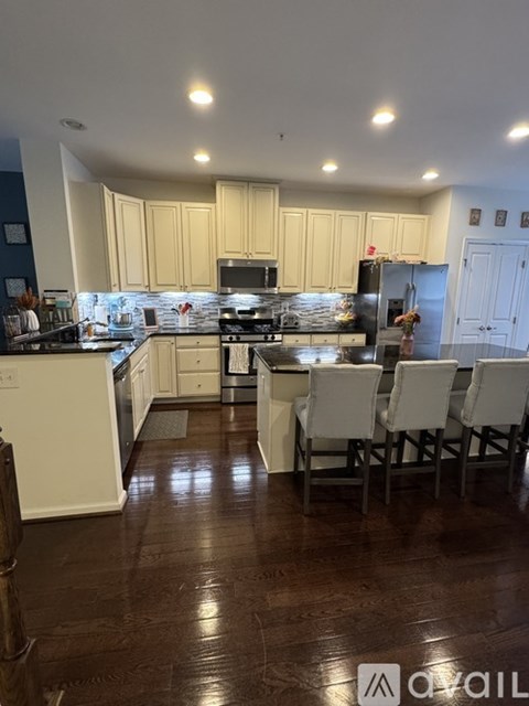 A kitchen with white cabinets and a darker floor.