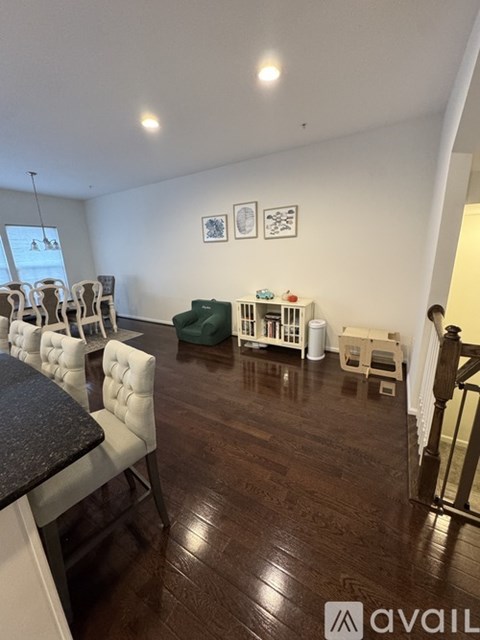 A living room with white chairs and a green armchair.